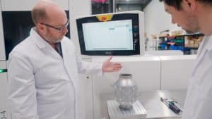 production of heat exchange in lab environment with two men focusing on the details of the component