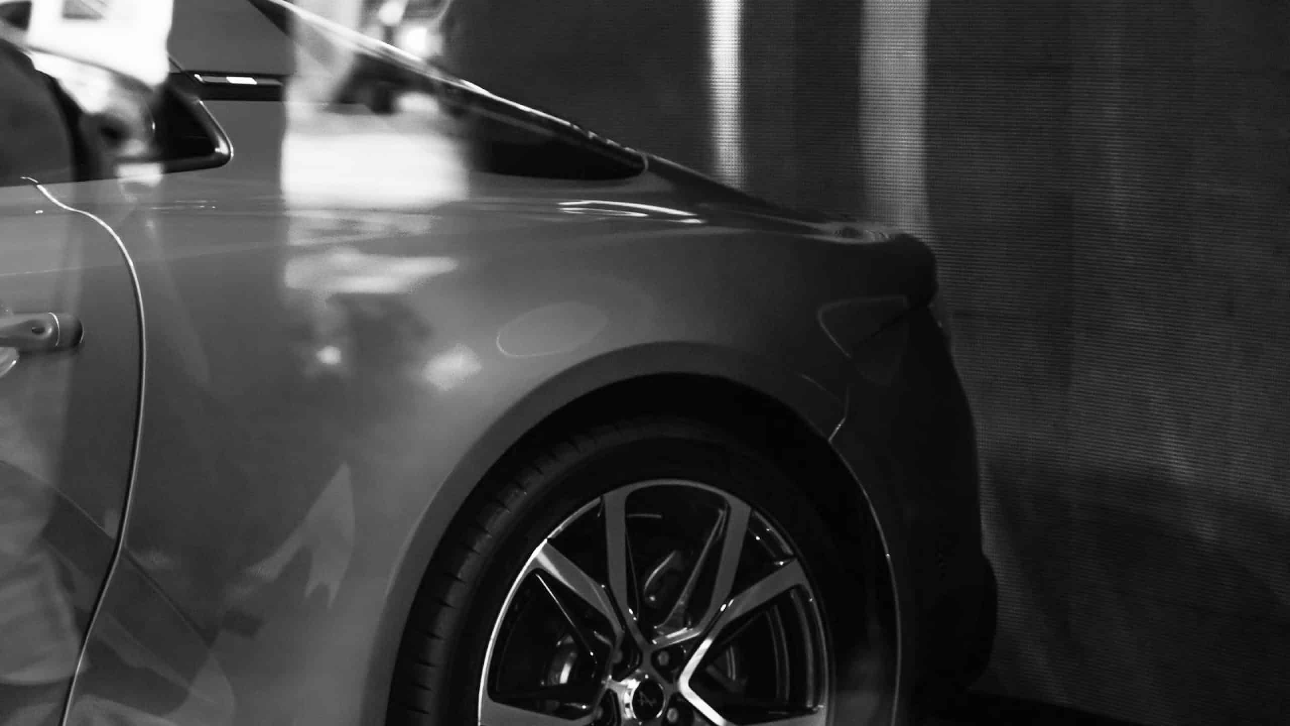 black and white image of sports car rear-wheel